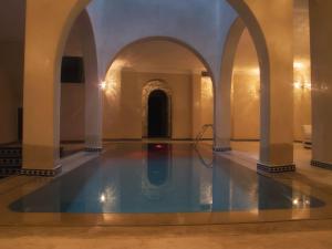 a swimming pool in a building with an archway at Lina Ryad & Spa in Chefchaouene