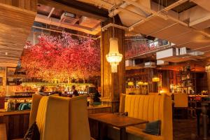 a restaurant with a bar with yellow chairs at House Belfast Hotel in Belfast