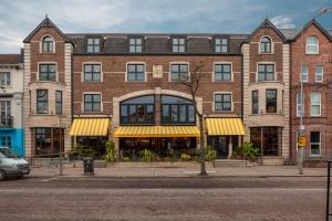 a large brick building with yellow and white awnings at House Belfast Hotel in Belfast