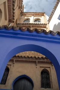 a building with an archway and a clock tower at Lina Ryad & Spa in Chefchaouene