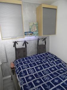 a bedroom with a blue and white bed with windows at Lütte Höög in Sierksdorf