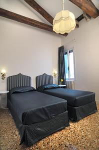 a bedroom with two beds and a chandelier at Ca' dell' Artista with Balcony and Terrace in Venice