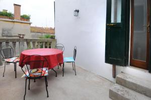 a table and chairs with a red cloth on a patio at Ca' dell' Artista with Balcony and Terrace in Venice