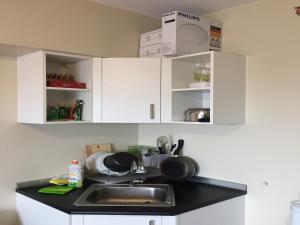 a kitchen with white cabinets and a sink at Avida Towers Condotel in Davao City