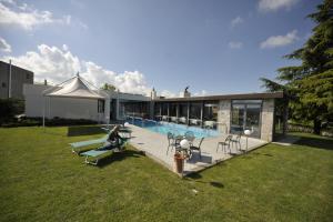 a person sitting on a lawn next to a swimming pool at Ca' Del Lupo in Montelupo Albese