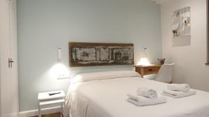a white bedroom with a bed with towels on it at Hotel San Nikolas in Hondarribia