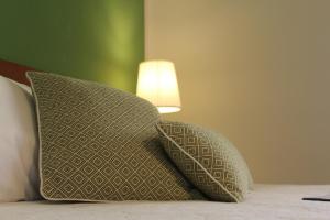 two pillows sitting on a bed next to a lamp at Alle Terme B&B in Rapolano Terme