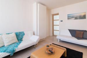 ein Wohnzimmer mit einem weißen Sofa und einem Tisch in der Unterkunft Duplex in De Panne