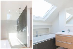 a bathroom with a skylight and a shower and a sink at Duplex in De Panne