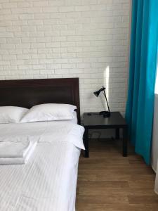 ノヴォシビルスクにあるApartments Domantのベッドルーム1室(ベッド1台、ランプ付きテーブル付)