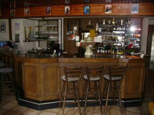 a bar with four stools in a room at Hotel Kraichgauidylle in Malsch