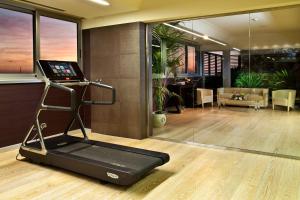 ein Zimmer mit Fitnessraum, ausgestattet mit Laufband und Laptop in der Unterkunft Enea Hotel Pomezia in Pomezia