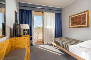 a hotel room with a bed and a television at Enea Hotel Pomezia in Pomezia