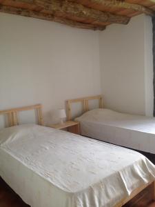two beds in a room with white walls at Casa Da Lava in São Roque do Pico