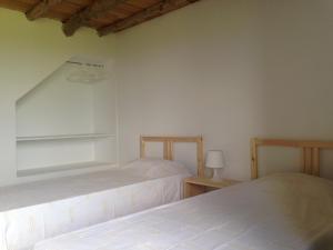 a bedroom with two beds and a lamp on a table at Casa Da Lava in São Roque do Pico