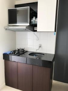 a kitchen with a sink and a microwave at Sam’s Parahyangan Residence in Bandung