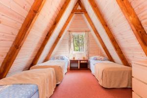 a room with three beds in a attic at Gryf Domki Pobierowo in Pobierowo +108 photos