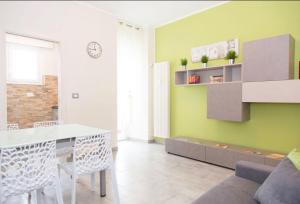 salon ze stołem i zieloną ścianą w obiekcie Gru House w mieście Grugliasco +12 zdjęć