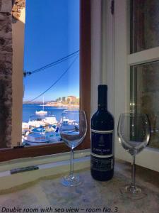 una botella de vino junto a dos copas de vino en City Rooms Šibenik, en Šibenik