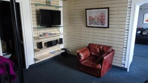 een bruine leren stoel in een kamer met een televisie bij Appart T4 Luchon plein centre in Luchon