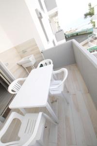 
a white chair sitting on top of a wooden floor at Trilocale Rivabella in Gallipoli
