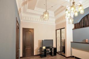 a living room with a television and a chandelier at Мини-Отель "Навруз" in Kharkiv