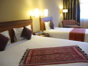 Postel nebo postele na pokoji v ubytování Hotel Grand Continental Kuching