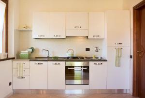 a kitchen with white cabinets and a sink at Appartamento panoramico in Parella