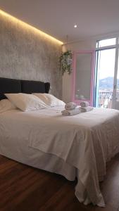 1 dormitorio con 1 cama blanca grande y ventana en Hotel San Nikolas, en Hondarribia