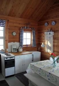 a kitchen with white cabinets and a stove in a cabin at Liinaranta in Kalmari