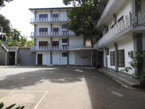 an empty parking lot in front of a building at Paradise Inn in Kandy