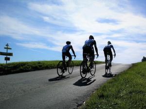 um grupo de três pessoas andando de bicicleta por uma estrada em Casa Bicicletta em Fuschl am See