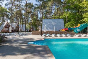 a swimming pool with a slide and a playground at Gryf Domki Pobierowo in Pobierowo