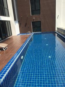 a swimming pool with blue tiles in a building at The High One Condo B in Ban Laem Thaen