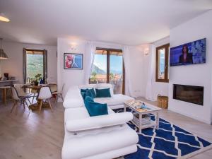 een woonkamer met witte banken en een blauw tapijt bij Villa Rosalia in Menaggio