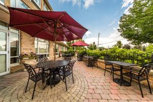 a patio with tables and chairs and an umbrella at Monte Carlo Inn Markham in Markham