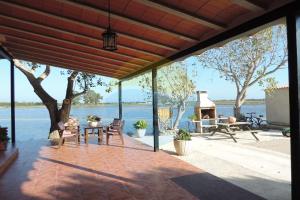eine Terrasse mit Blick auf das Wasser in der Unterkunft Mas de Felip - Casa rural con piscina privada en el Delta - Deltavacaciones in Riumar