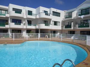 a swimming pool in front of a building at RealRent Costa Teguise Beach in Costa Teguise