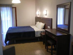 a bedroom with a bed and a desk and a mirror at Megalos Mourtias in Alonnisos +26 photos