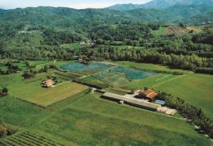 une vue aérienne sur une ferme avec un train dans un champ dans l'établissement Agriturismo La Praduscella, à Fivizzano