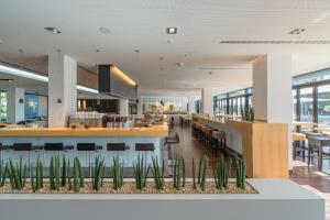 a lobby of a restaurant with a bar and chairs at Lufthansa Seeheim - More than a Conference Hotel in Seeheim-Jugenheim