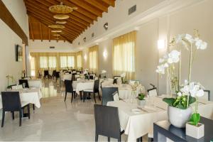 ein Esszimmer mit weißen Tischen und Stühlen in der Unterkunft AS Hotel Sempione Fiera in San Vittore Olona