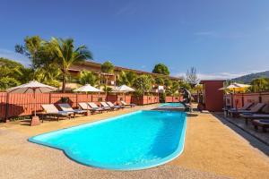 una piscina in un hotel con sedie e ombrelloni di Maleedee Bay Resort ad Aonang Beach