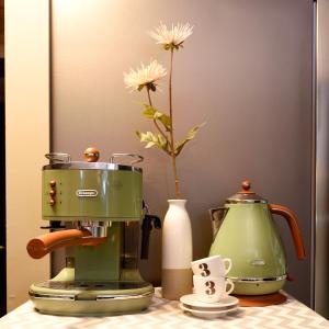 une cafetière verte et un vase avec une fleur dans l'établissement The One Hostel Hongdae in Seoul - Foreigner Only, à Séoul