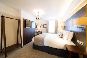 um quarto de hotel com uma cama grande e uma televisão em The Colney Fox by Innkeeper's Collection em London Colney