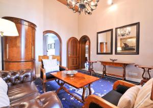 a living room with leather furniture and a table at Boutique Hotel Windsor - The Charming City Hotels in Düsseldorf