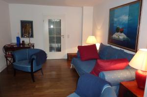 ユーバーリンゲンにあるVilla Elmenhorstのリビングルーム(青いソファ、赤い枕付)