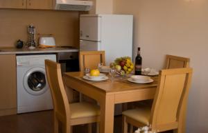 a kitchen with a table with a bowl of fruit and a refrigerator at SB Rentals Apartments in Royal Dreams Complex in Sunny Beach
