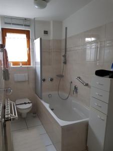 Un baño con bañera y ducha y un inodoro. en Ferienwohnung, Monteurwohnung "Strunde", en Bergisch Gladbach