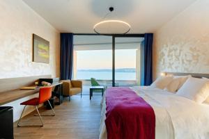 um quarto de hotel com uma cama grande e uma escrivaninha em Hotel Ola - Adults Only em Trogir